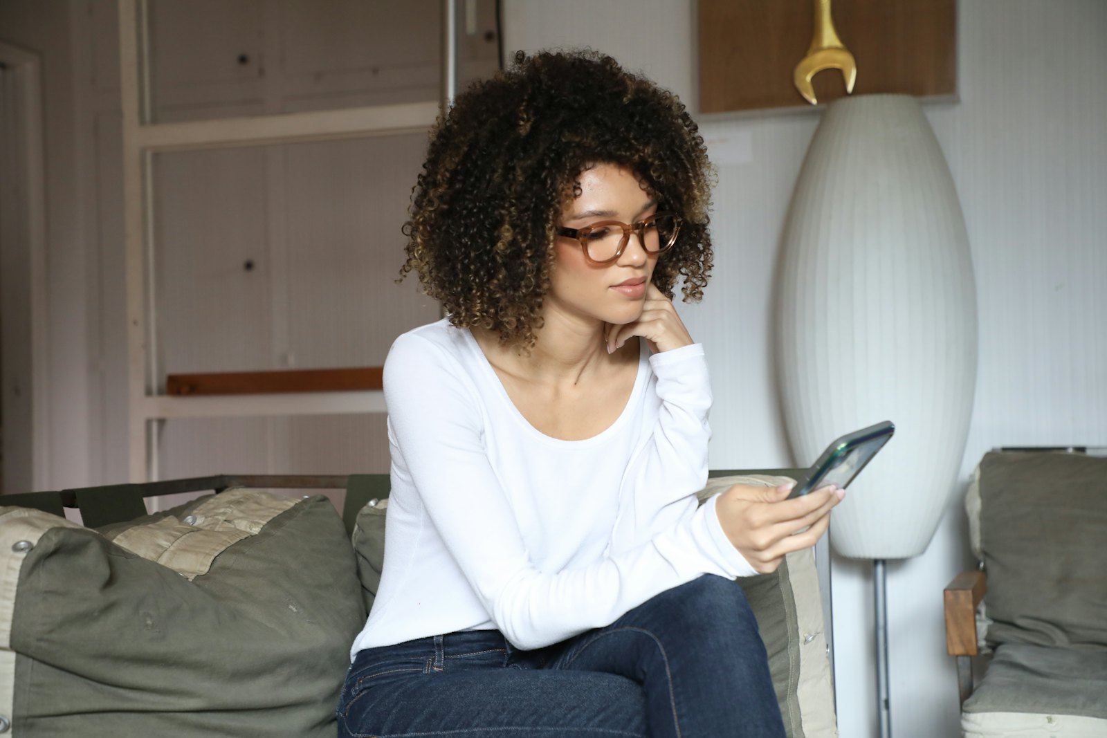 A customer on a sofa at home getting support on her phone