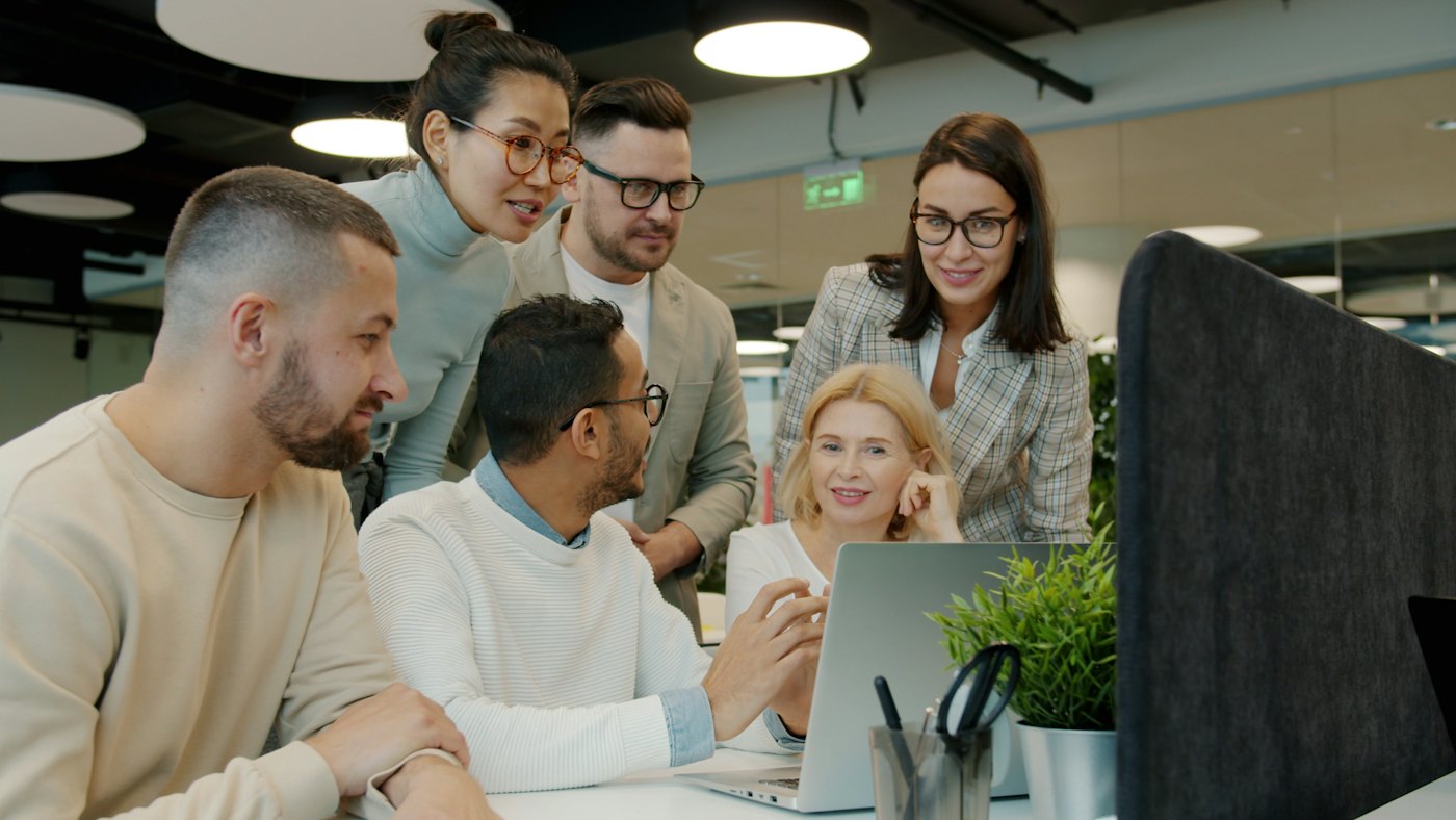 A team gathered around a laptop, working together