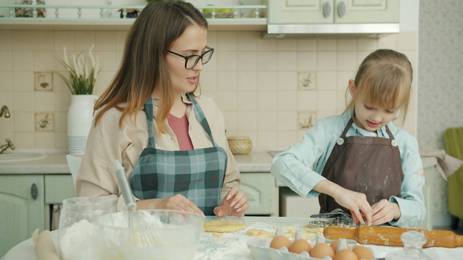 A mother and daughter baking bread together in the kitchen