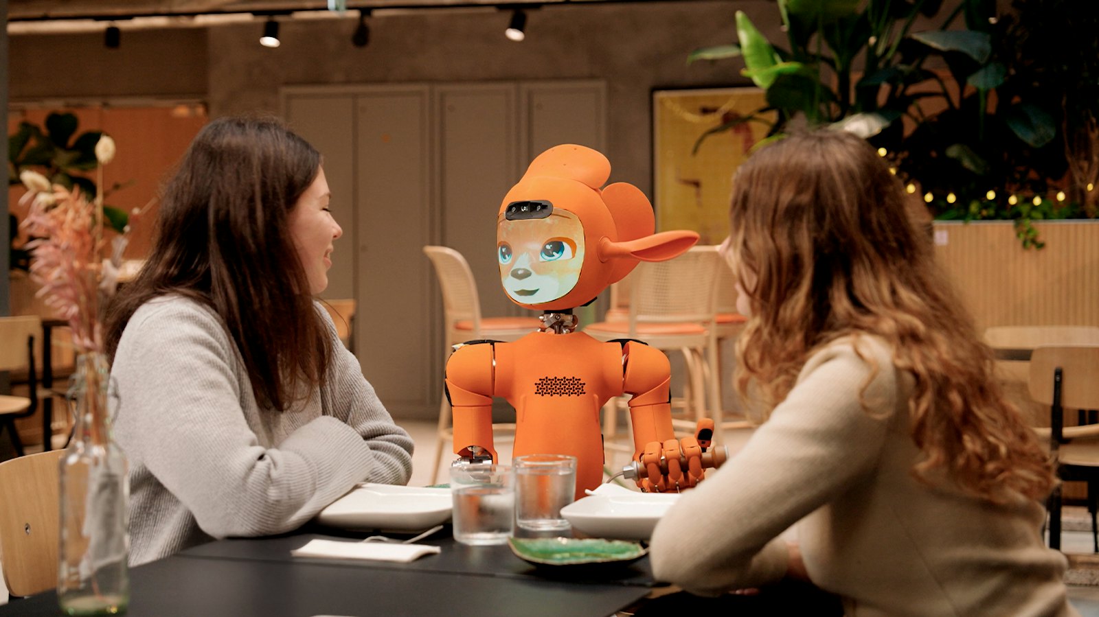 A service robot attending to guests at a restaurant table