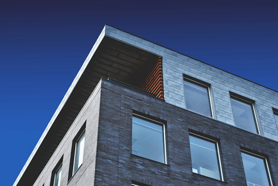Dark brick building corner against a deep blue sky