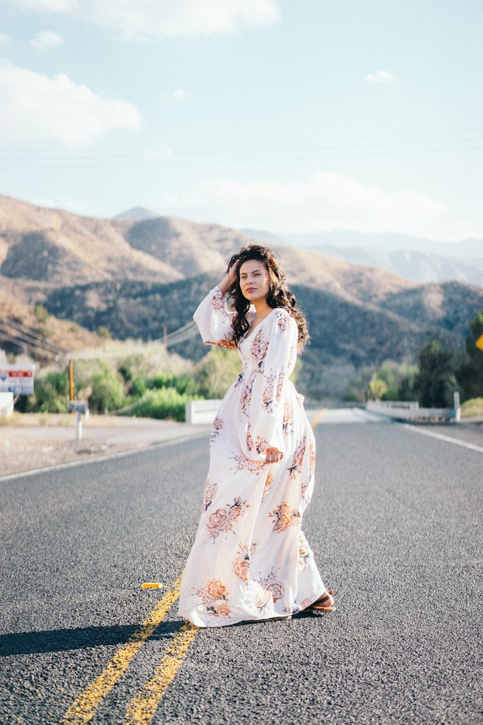 Bride in a floral gown on a quiet mountain road
