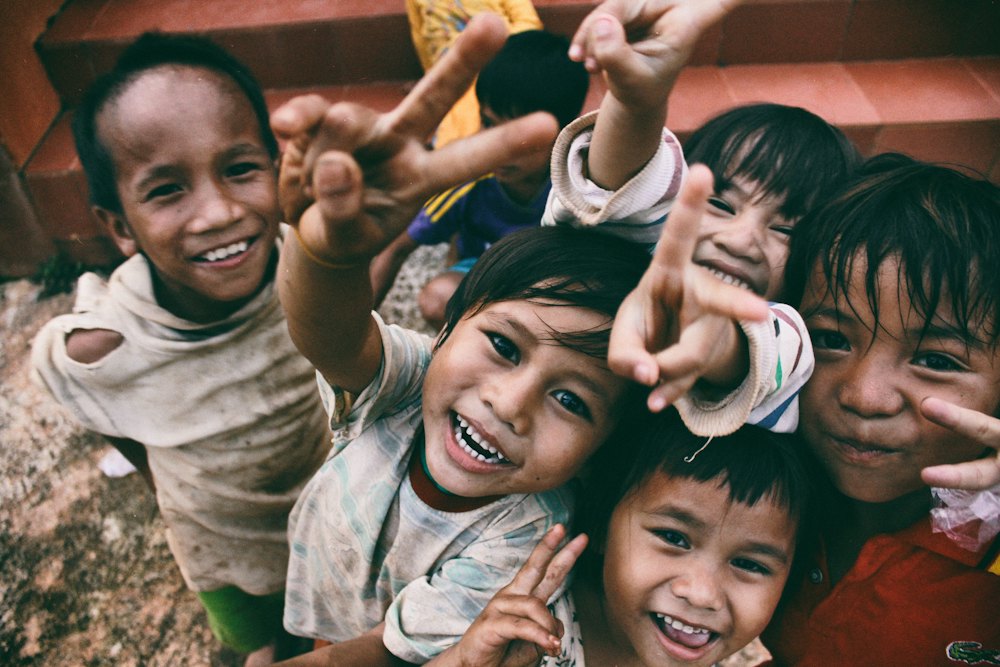 Group of smiling children reaching toward the camera