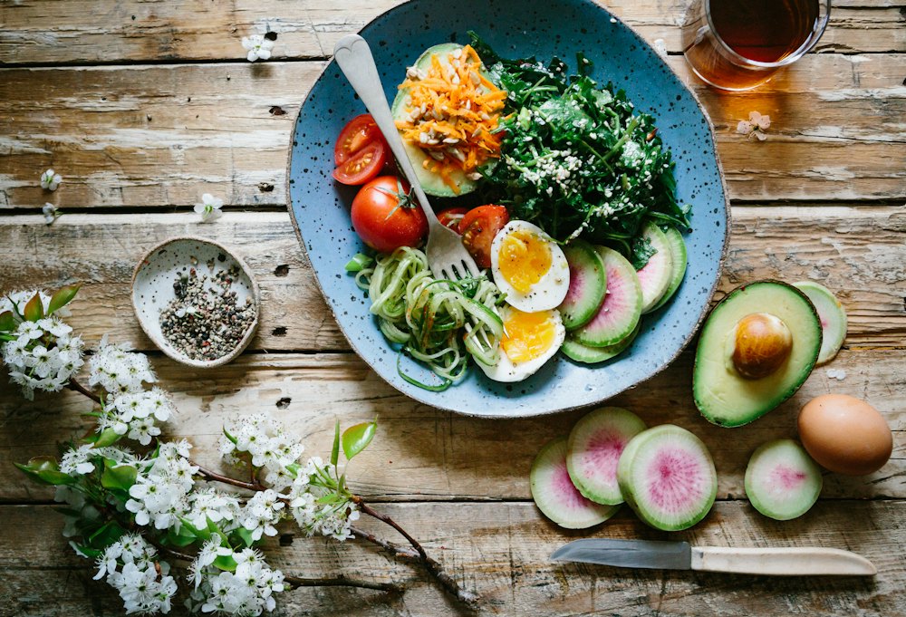 Colourful bowl of vegetables, grains and herbs on a table