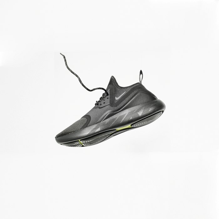 Black running sneaker captured mid-air