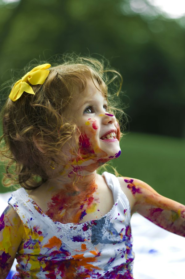 Smiling girl with paint on her face looking up
