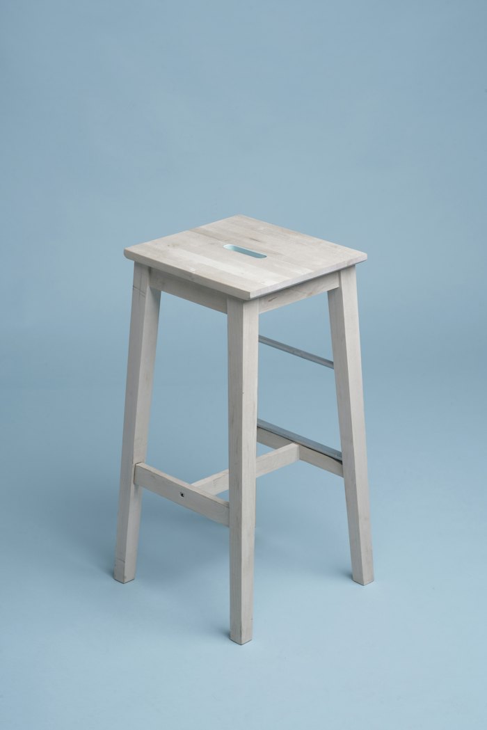 Pale wooden stool on a blue background