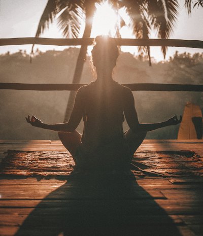 Teacher practicing yoga outdoors at sunrise