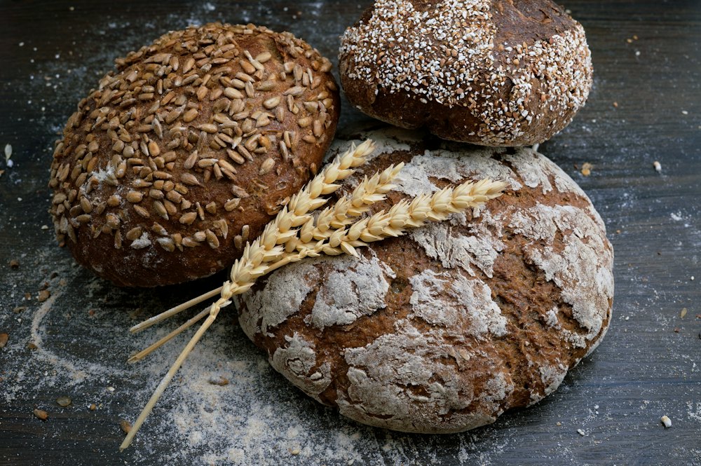 Crusty sourdough loaves cooling on a wooden board