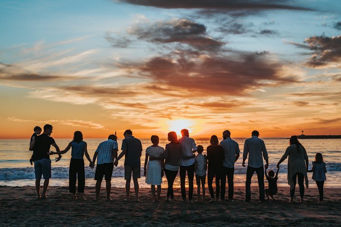 Family walking along a beach at sunset
