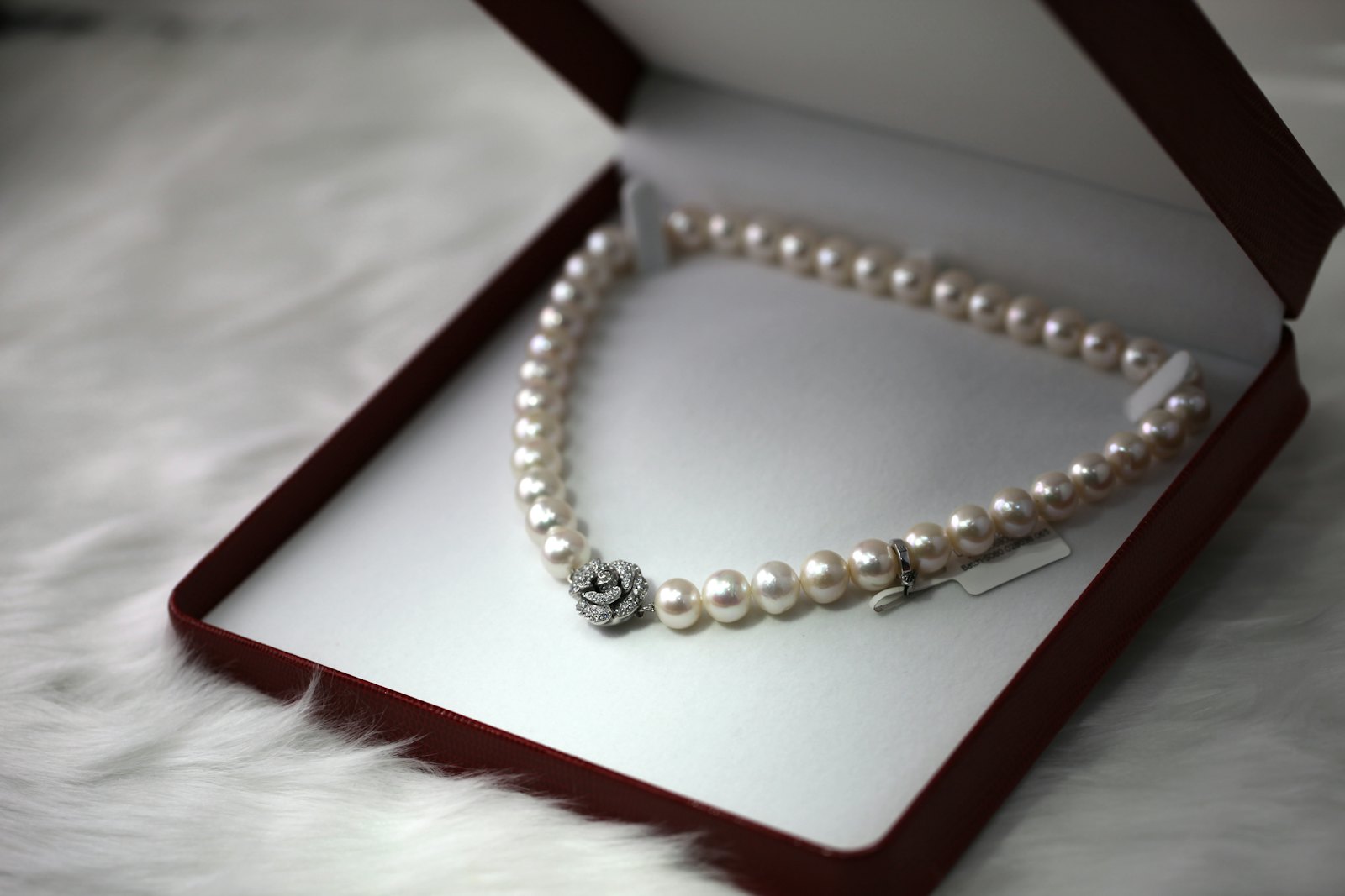 Pearl necklace with a diamond clasp in an open presentation box