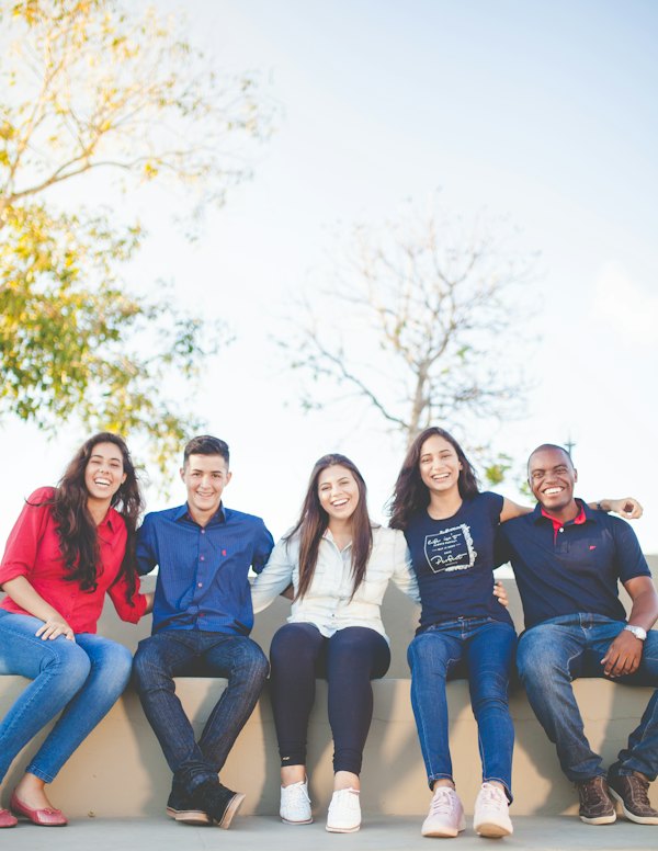Group of students sitting together outside on the grass