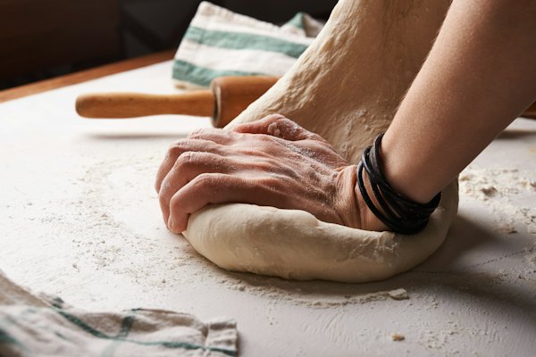 Baker kneading dough on a floured counter