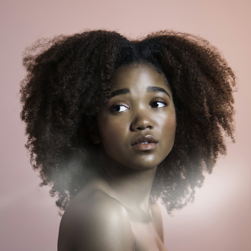 Portrait of a woman with curly hair against a plain background