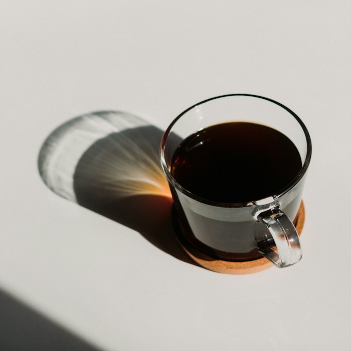 Glass cup of black filter coffee in sunlight