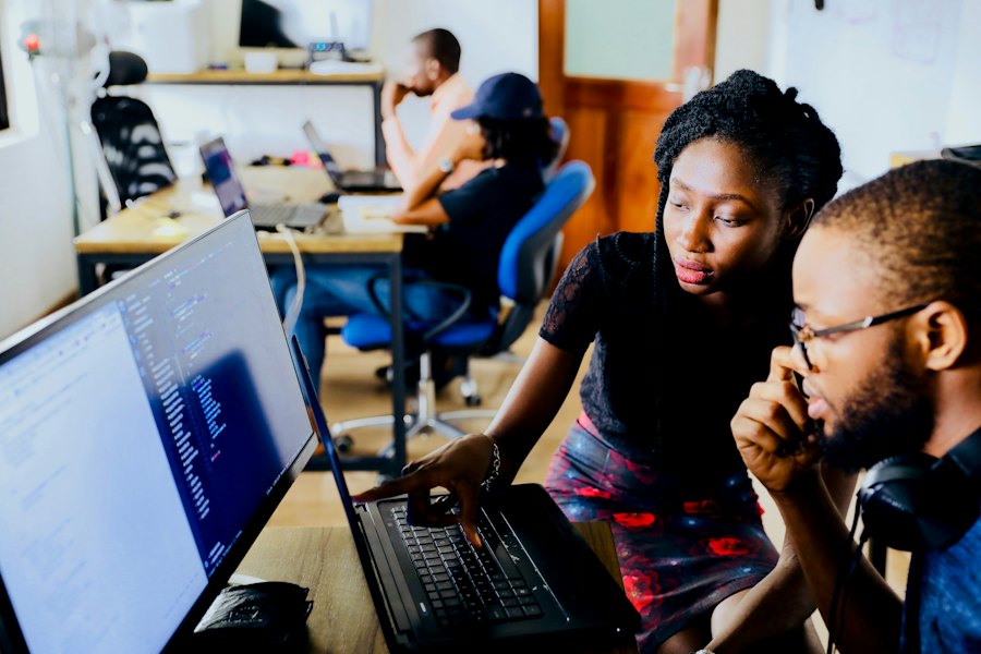 Two colleagues talking over a laptop