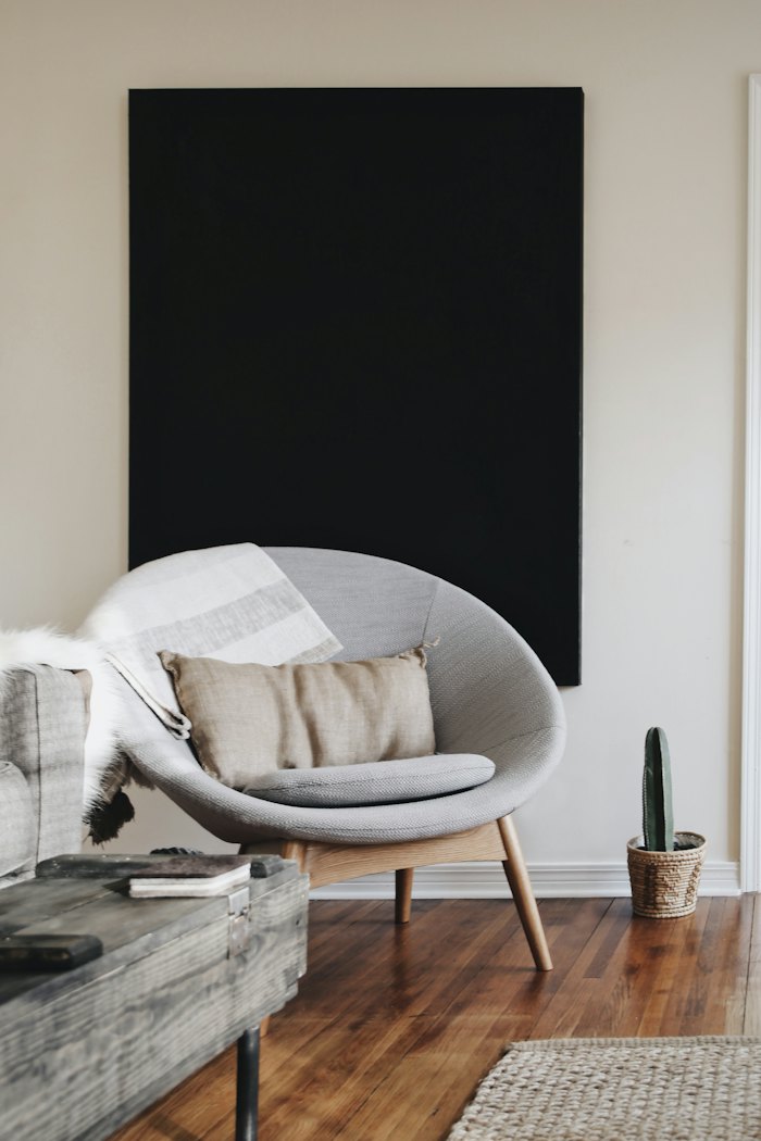 Curved grey lounge chair in a bright room