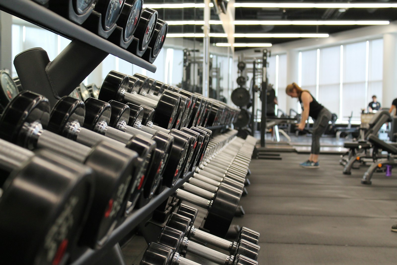 Dark gym floor with racks and barbells
