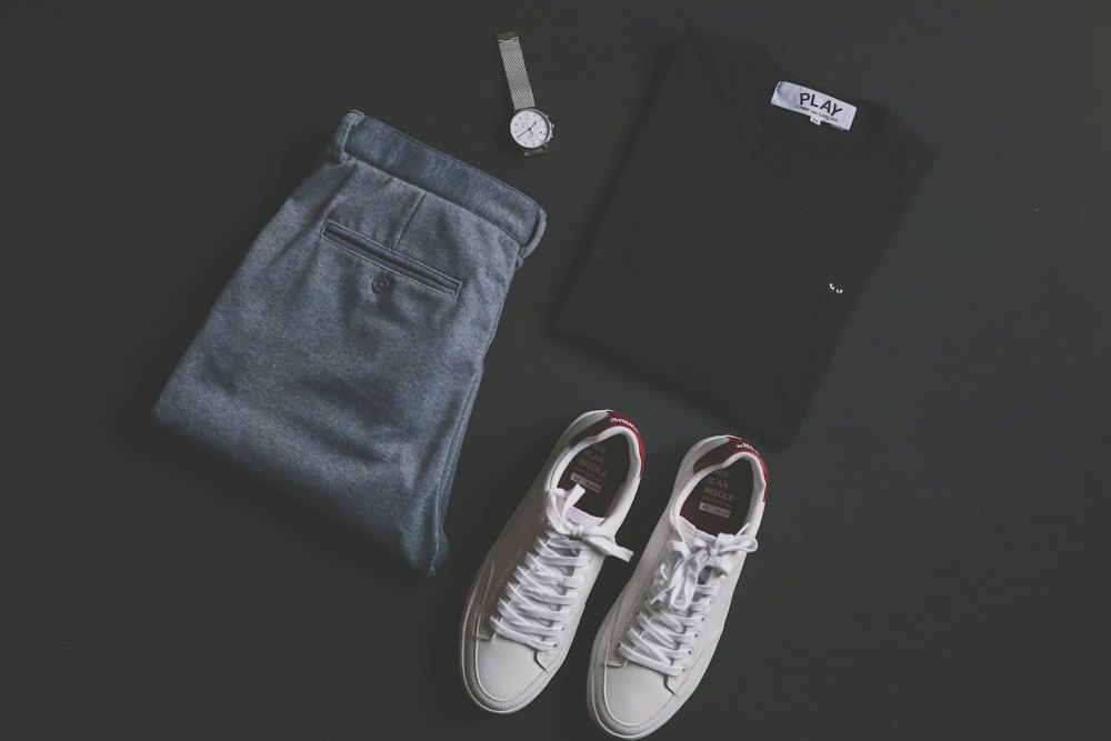 White sneakers laid out beside folded jeans