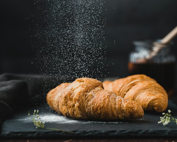 Butter croissant dusted with flour on a slate board