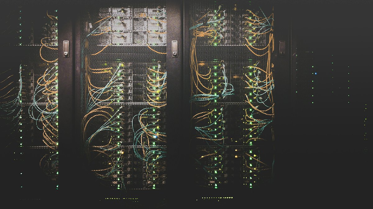 Server rack with bundles of patch cables and glowing status lights