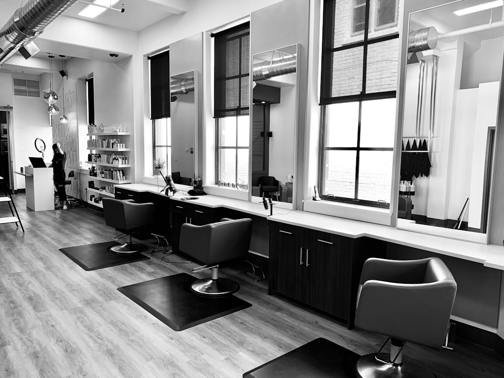 Minimal salon interior with mirrors, chairs, and natural light