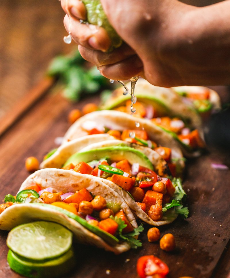 Tacos with avocado and salsa getting a squeeze of lime