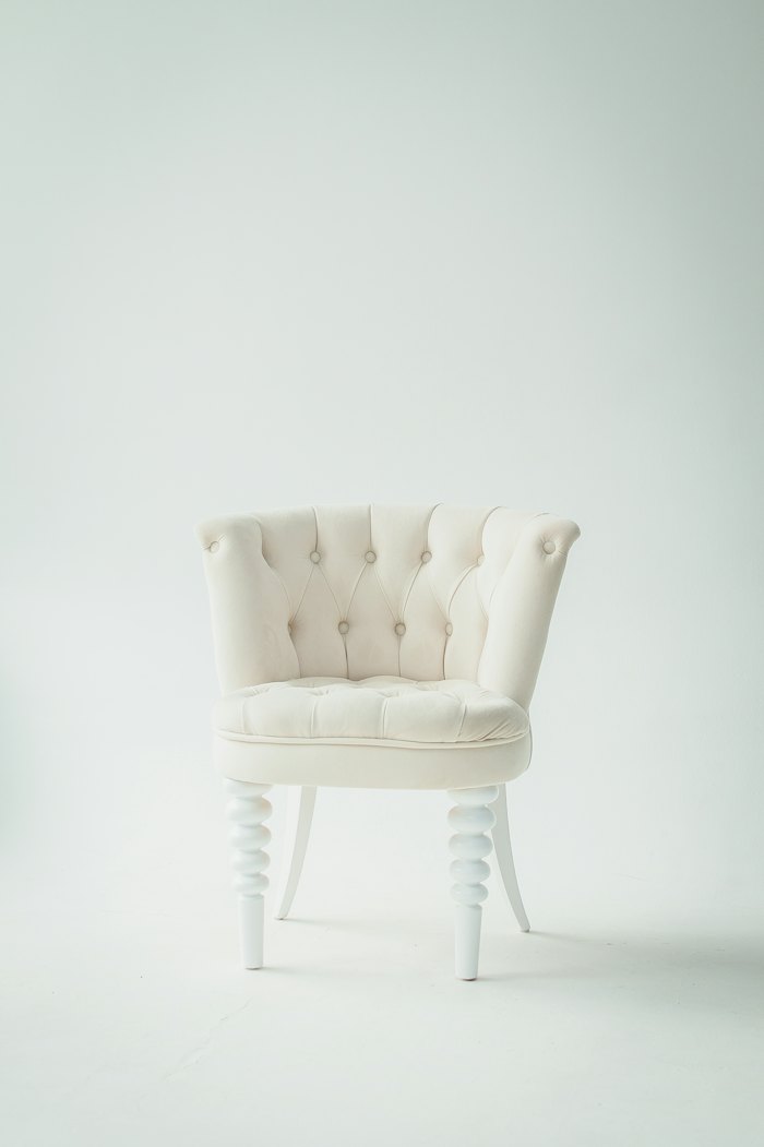 Lounge chair with woven seat against a plain wall