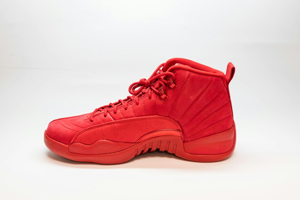 Red sneaker photographed from the side on a white background