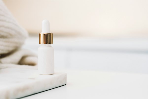White serum bottle with a gold dropper cap