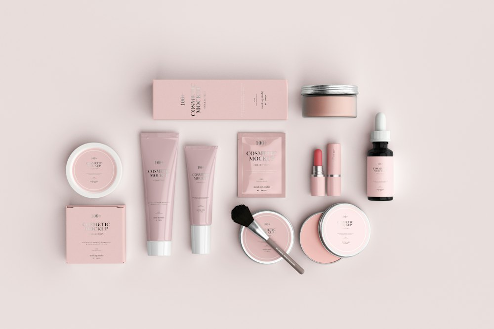 Pink skincare bottles and jars arranged on a pale pink surface
