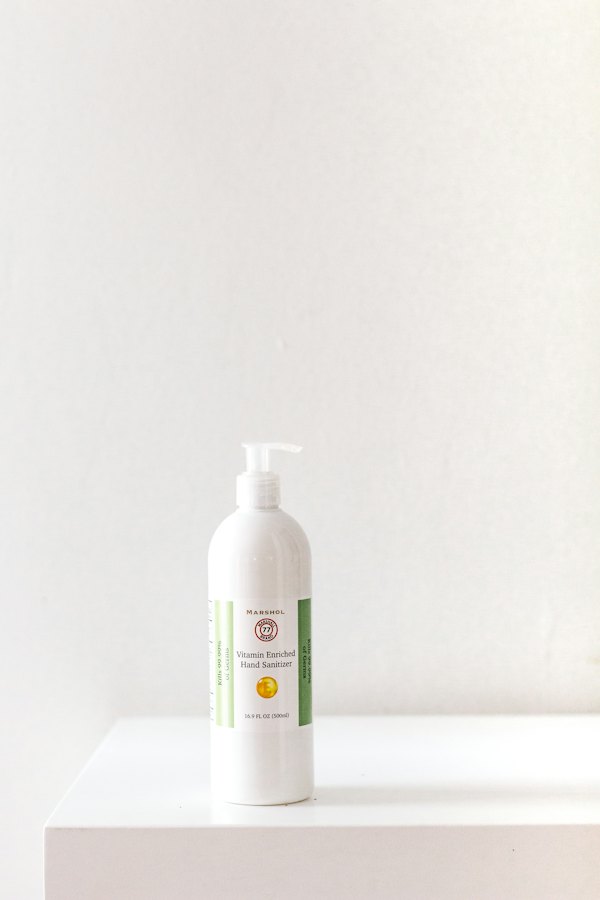 White pump bottle beside a green leaf