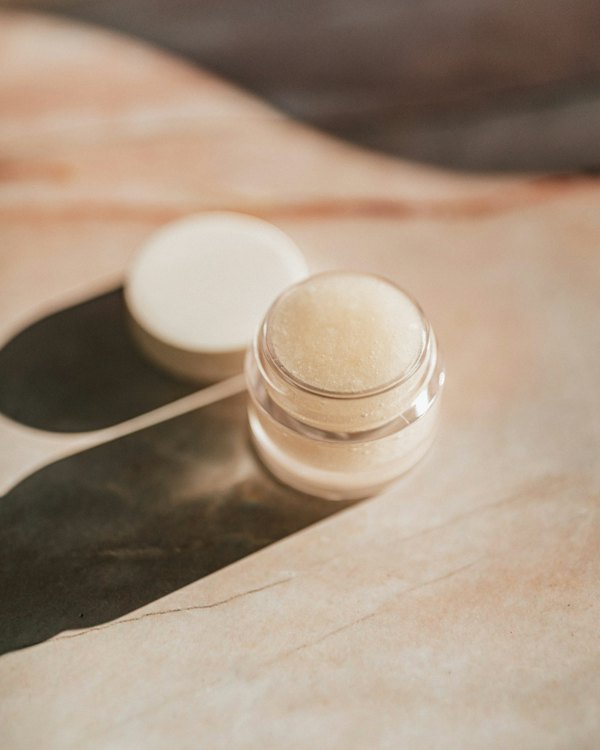 Open jar of cream catching afternoon sunlight