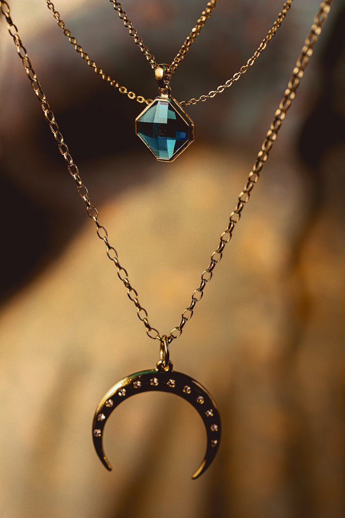 Gold chain necklace with a blue stone pendant
