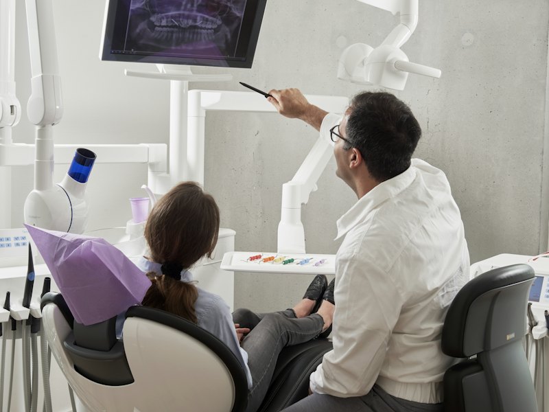 Dentist treating a patient reclined in a dental chair