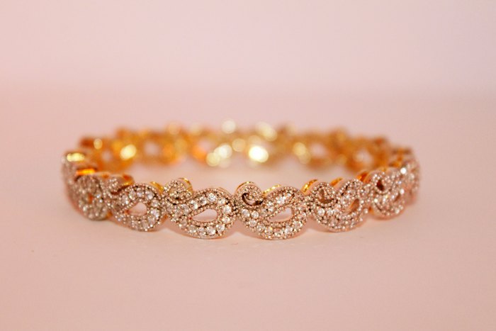 Rose gold bracelet laid on soft pink fabric