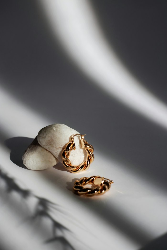 Pair of gold hoop earrings on a pale surface